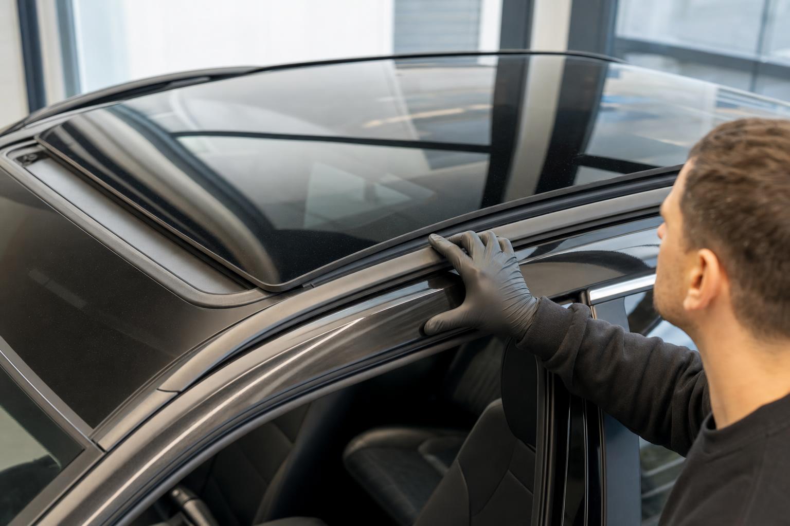 Technician inspecting car sunroof glass